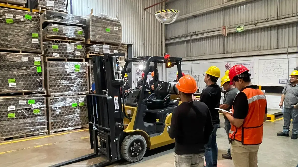 Instructor and trainees inspecting a forklift before the hands-on session