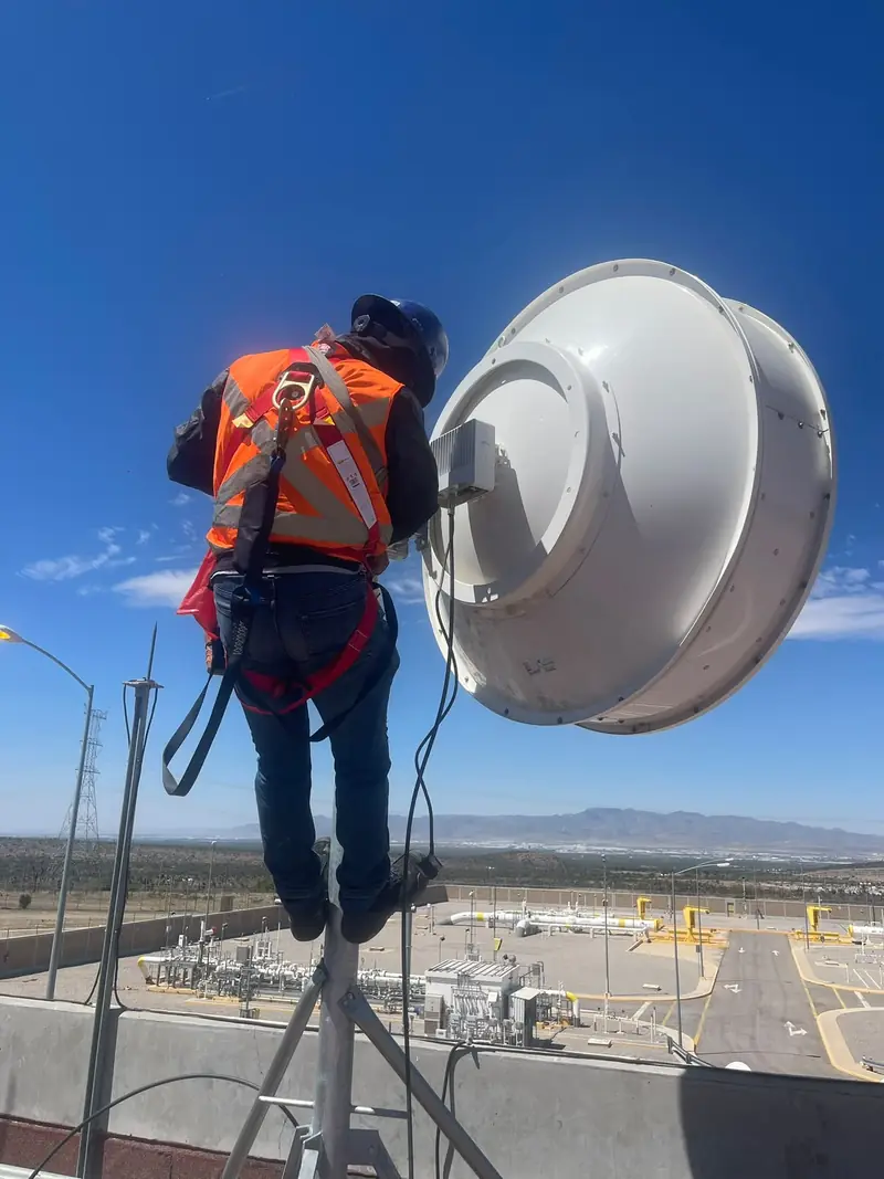 Técnico con arnés trabajando en altura