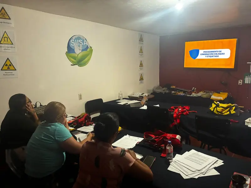 Participantes en el aula de SIISA con arneses y equipo de protección sobre las mesas durante un curso abierto