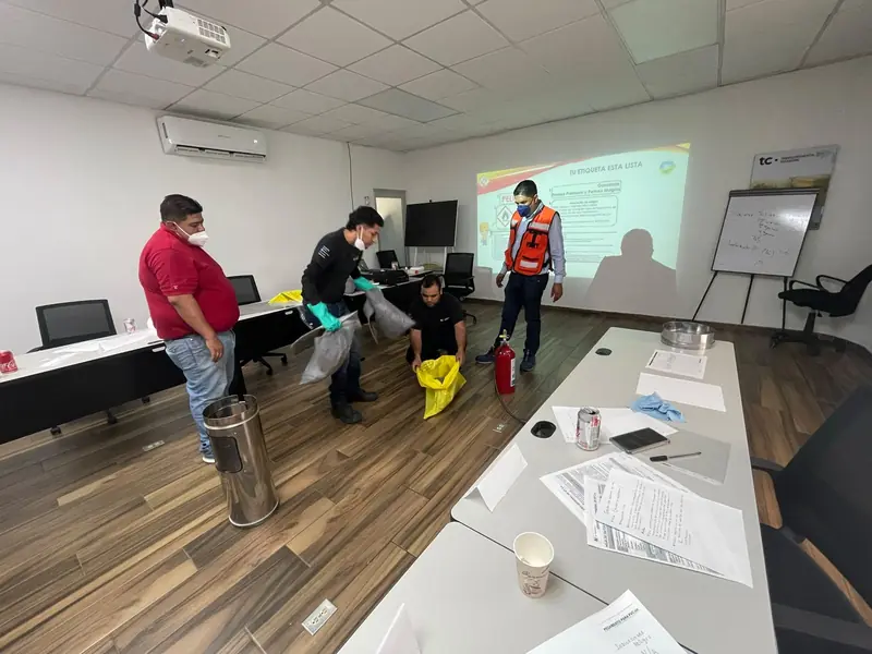 Participantes practican con extintores en un aula de capacitación de planta